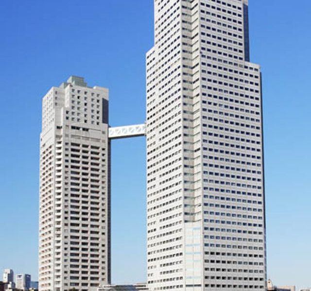 two tall buildings connected by a walkway