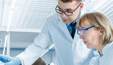 two scientists collaborating at a computer