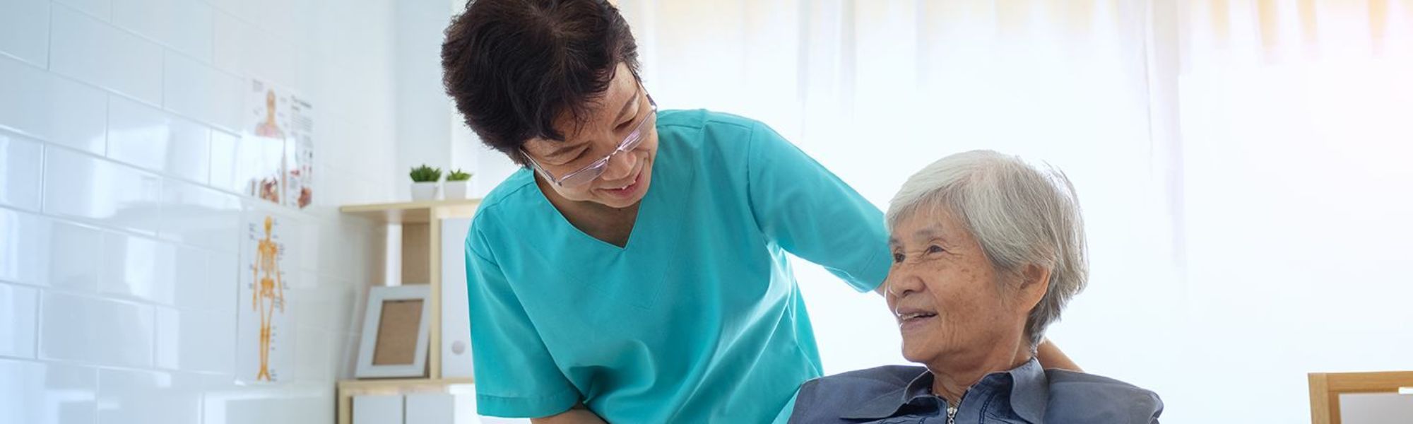 A nurse smiling down at her elderly patient