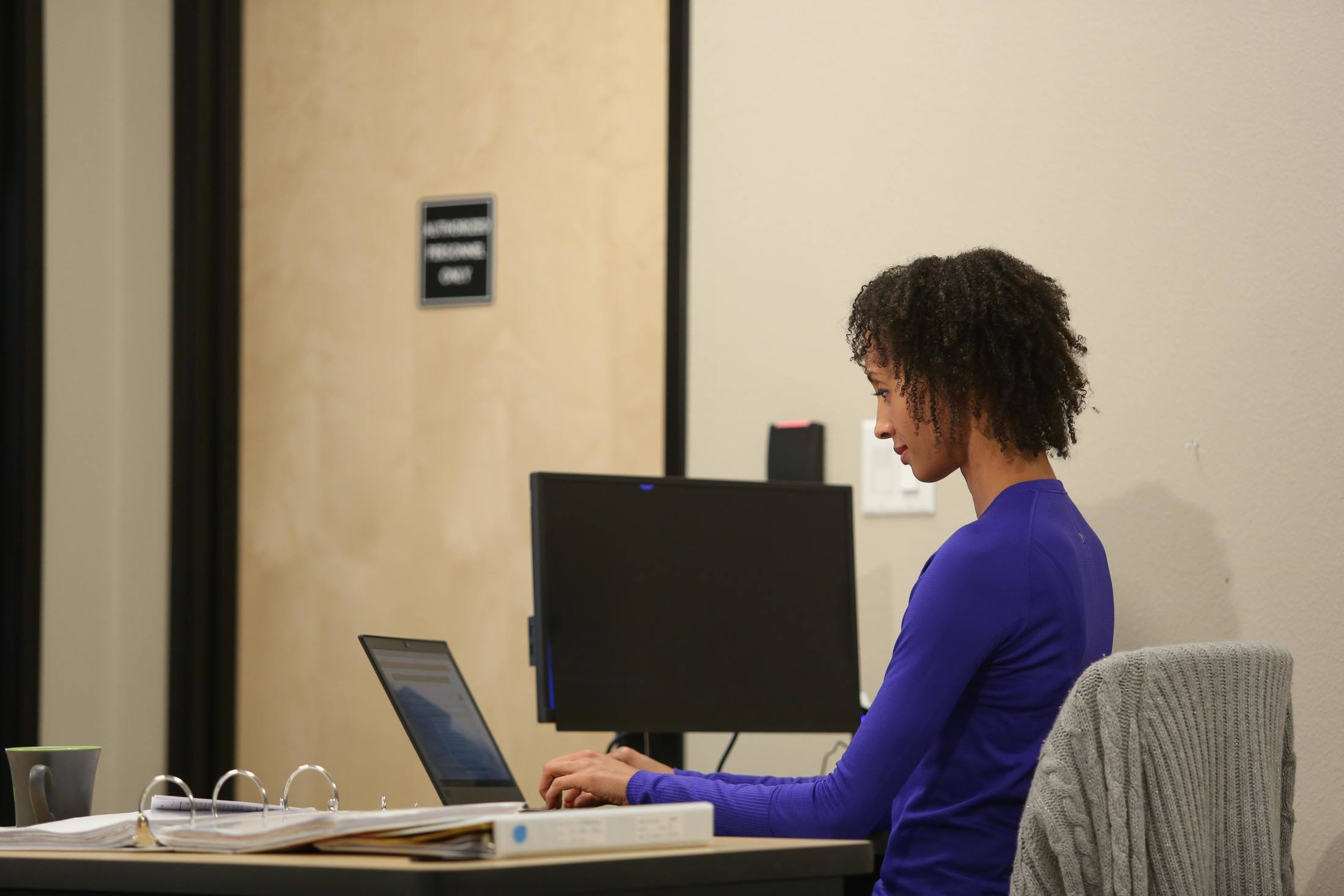 Woman working at a laptop in a doctors office