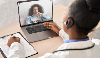 Woman at computer exploring global clinical trial barriers.