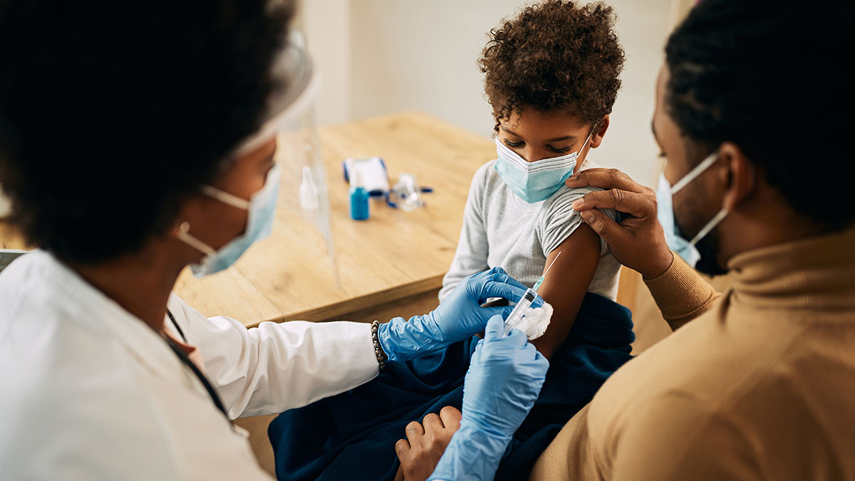 A pediatrician gives a boy a vaccine.