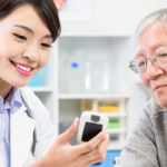 Doctor shows diabetes blood sugar test result to patient