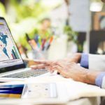 Doctor analyzing stats and graphs on a laptop