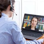 Woman with headset has video call on her laptop