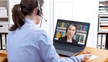Woman with headset has video call on her laptop
