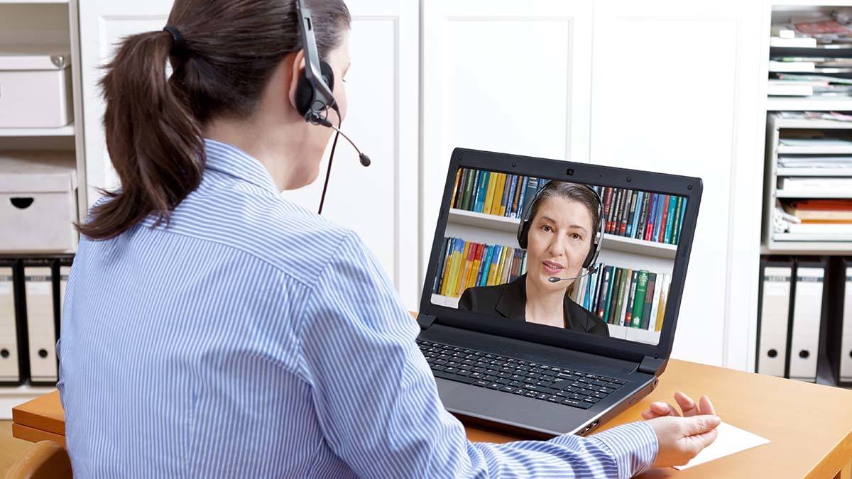 Woman with headset has video call on her laptop