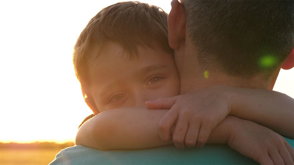 kid with rare disease hugging dad