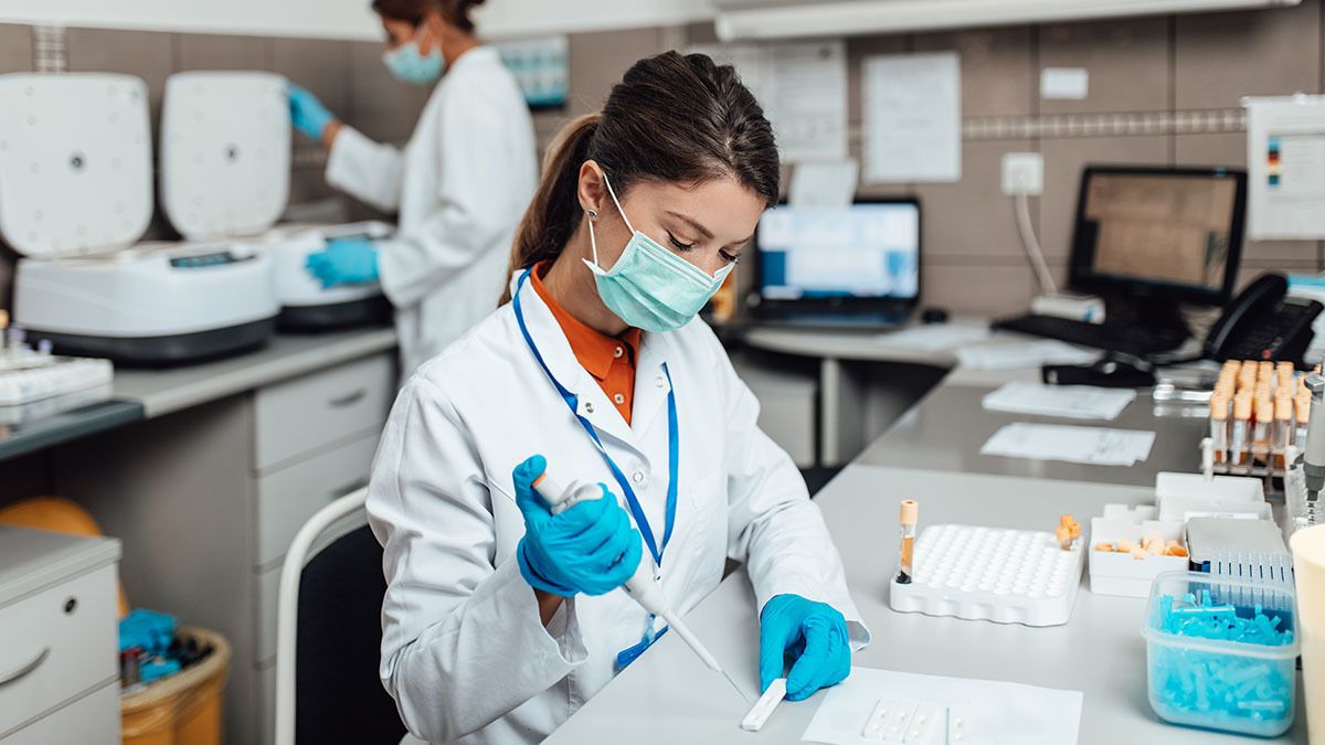 Two female scientists wearing face masks work in a laboratory