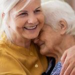 Smiling woman hugging her elderly mother