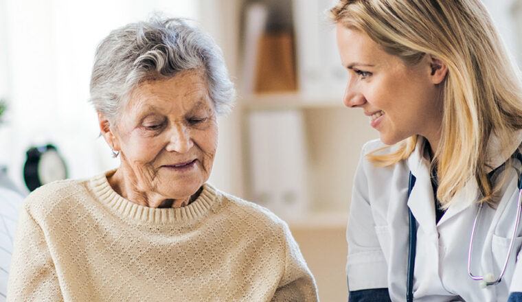 Elderly person speaking with home health nurse.