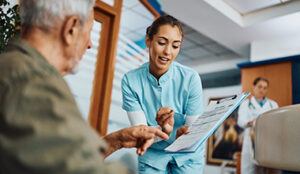 Patient and nurse having discussion with doctor taking notes.