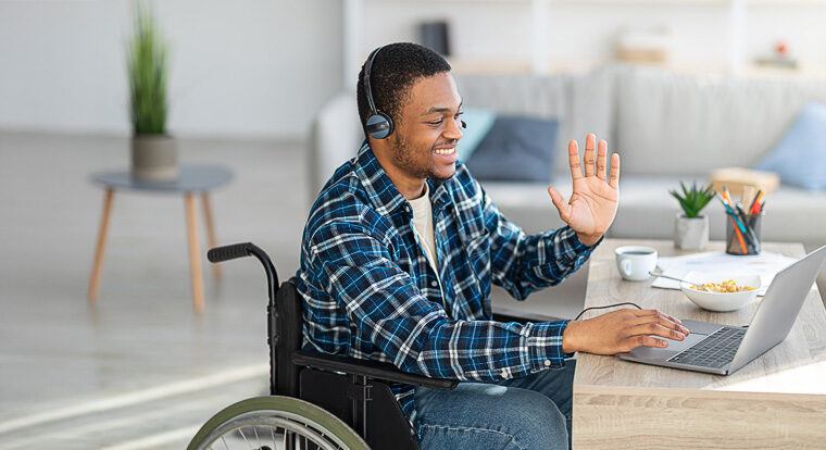 Man in wheelchair speaking to a clinical trial physician virtually