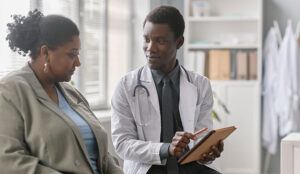 Male doctor speaking to female patient