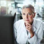 Drug development researcher reading a computer monitor