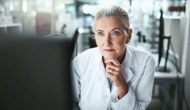 Drug development researcher reading a computer monitor