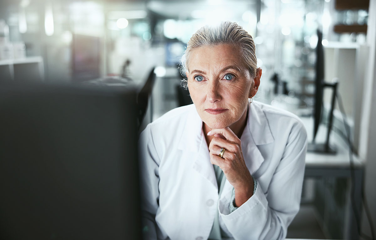 Drug development researcher reading a computer monitor