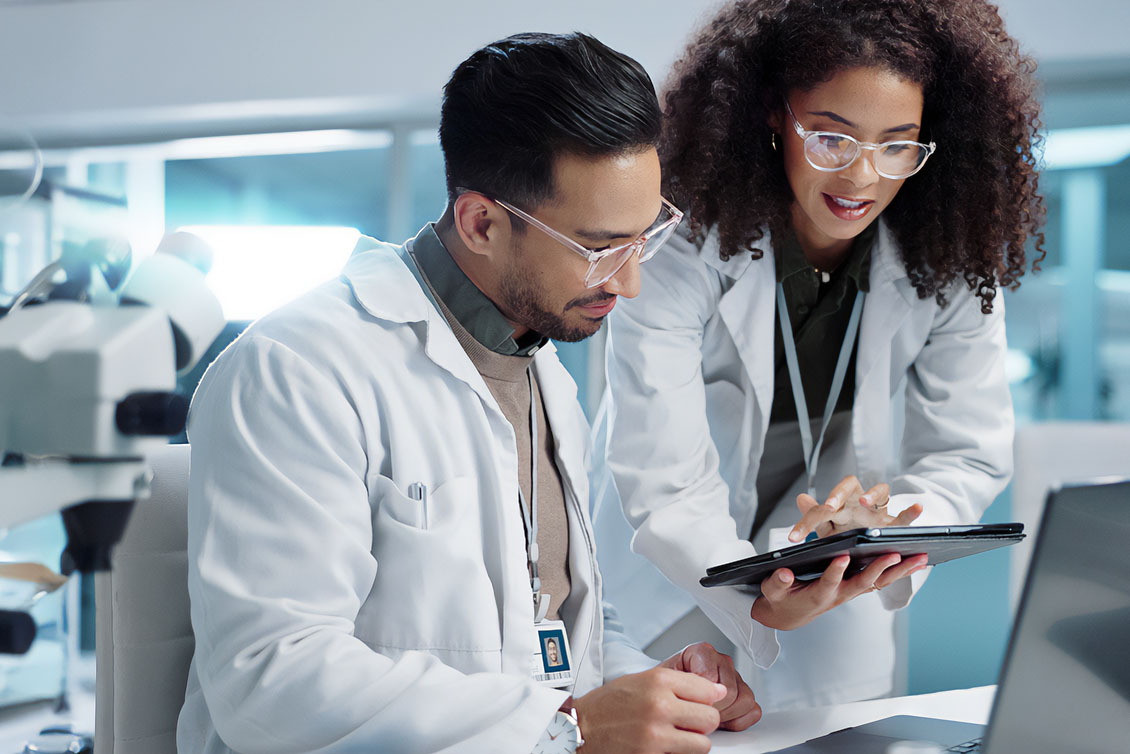 CRO and CDMO solutions expert working with a drug development researcher in a lab.