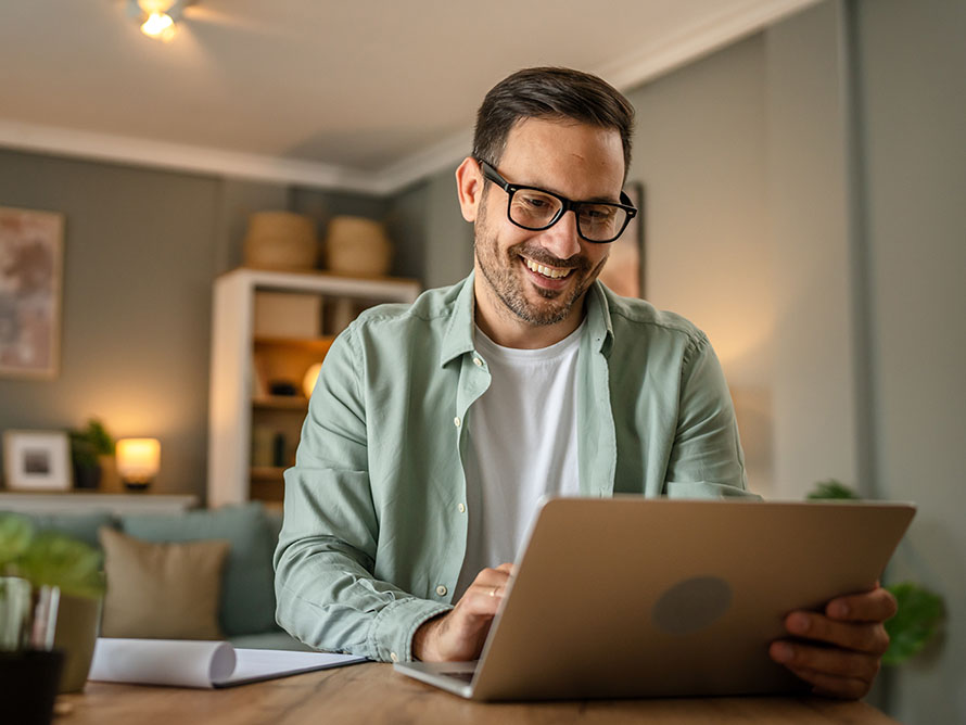 Young man, at home, using his laptop.