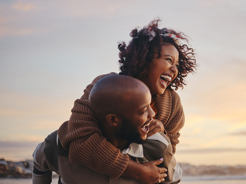 Male and female couple smiling on a beach