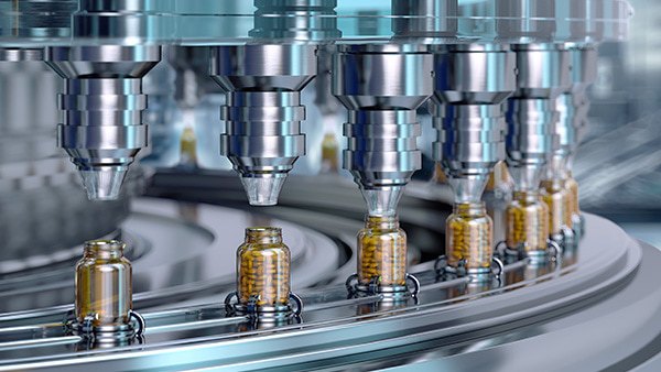 Pill bottles being filled on a drug development manufacturing and packing facility.