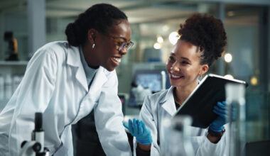 biotech-trial-strategy-women-lab-smiling-tablet
