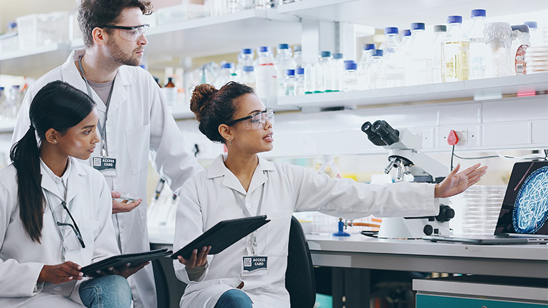 Laboratory of three researchers discussing clinical trial complexity